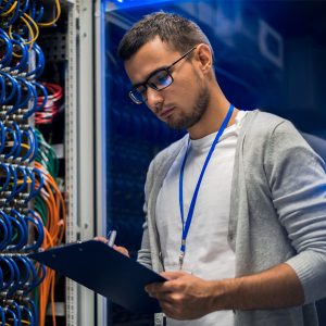 network engineer checking a server cabinet, at supercomputer in data center
